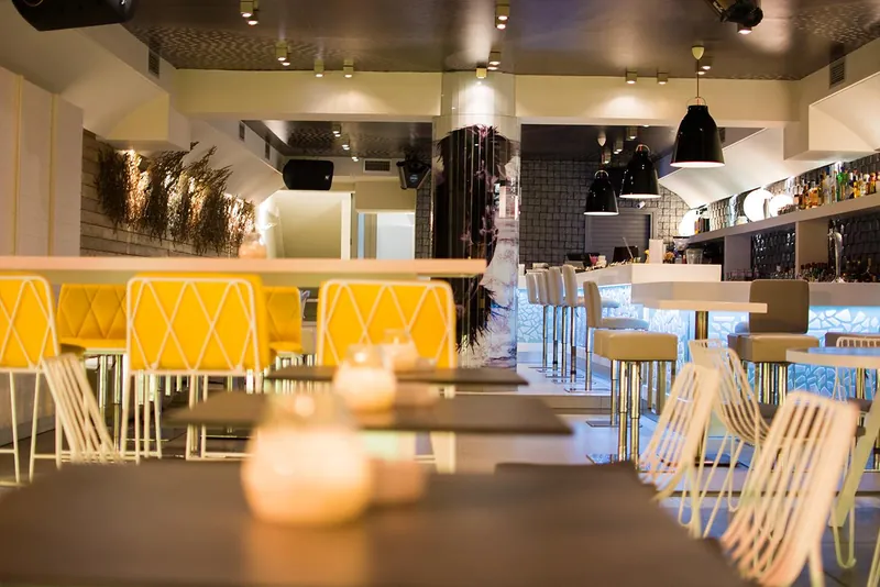 Les chaises et tables jaunes du Lobby Cocktail Bar