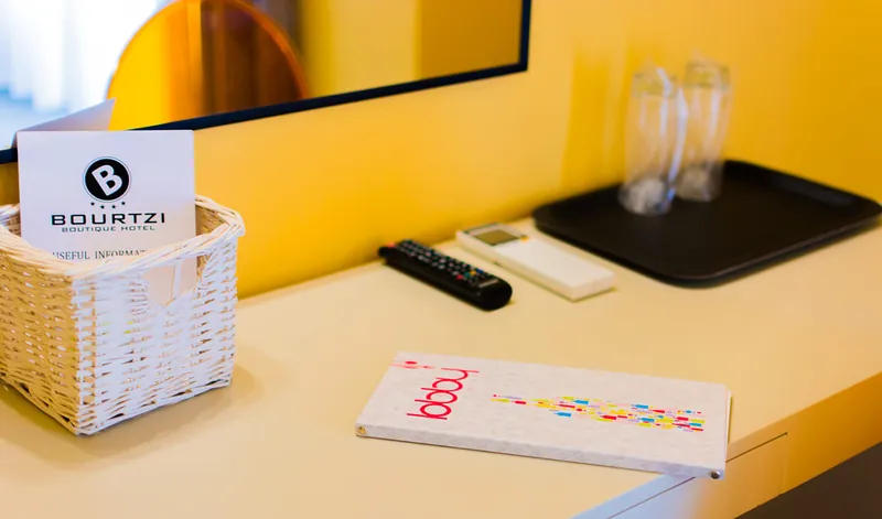 La carte du Lobby Cocktail Bar sur le bureau d’une chambre, à côté de la corbeille d’accueil