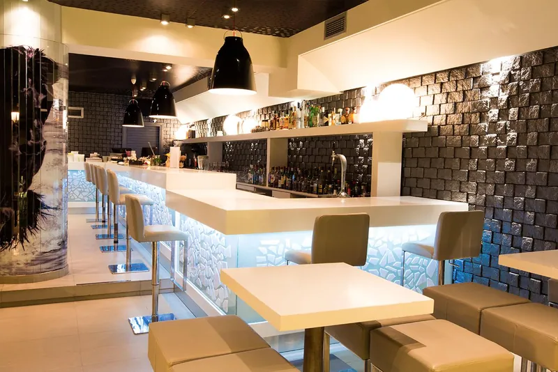 Des tables alignées le long du mur du bar