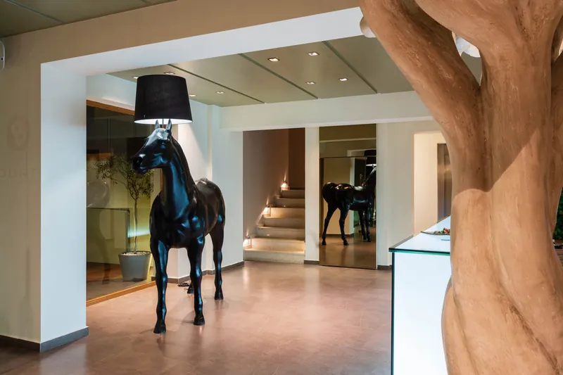 La lampe en forme de cheval noir et l’arbre sculpté du lobby
