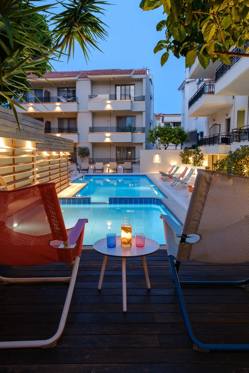 Une chaise et une petite table avec une bougie, face à la piscine
