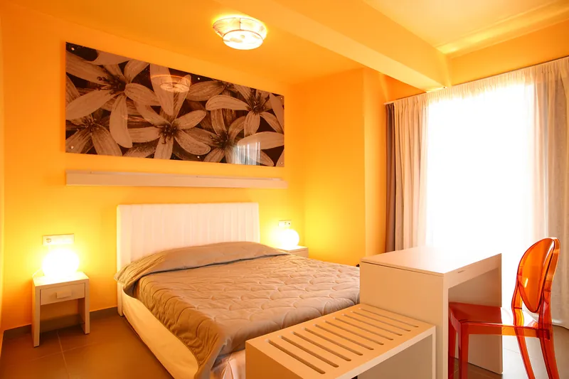 A Premium room in orange, with a floral print above the bed