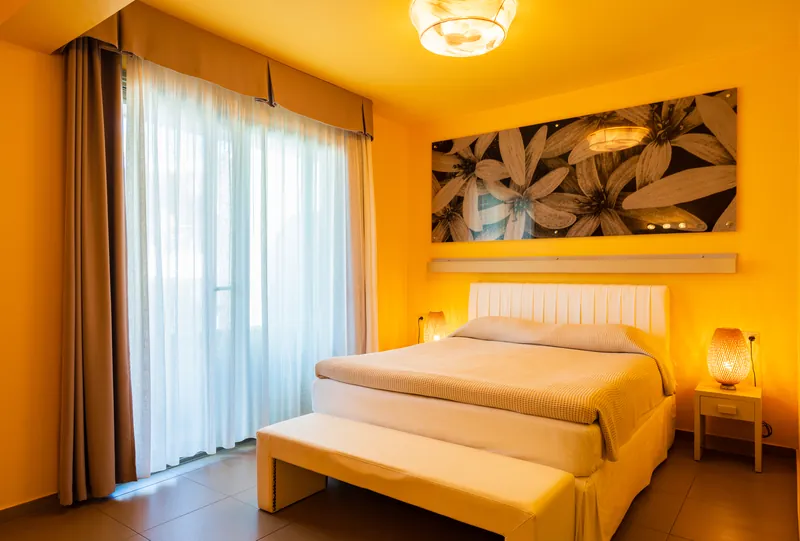 Une chambre Premium avec un banc au pied du lit et une image florale