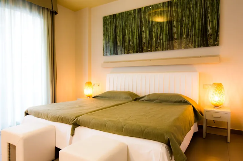 Une chambre Premium dans les tons verts, avec deux lits simples et une image de bambous