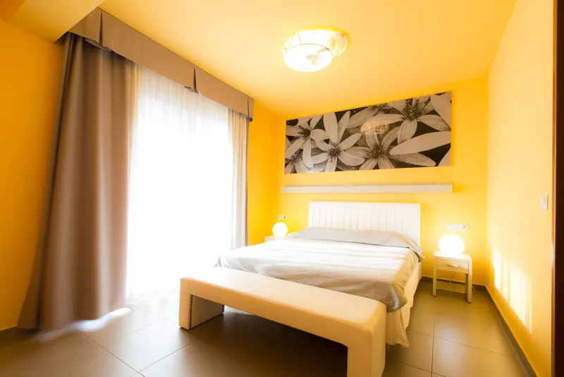 Une chambre Premium en jaune, avec un lit double et une image florale