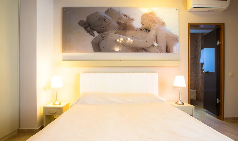 Une chambre Premium avec une image de sculpture au-dessus du lit