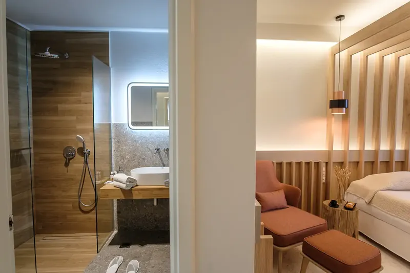 La salle de bains et le lit d’une chambre supérieure, côte à côte