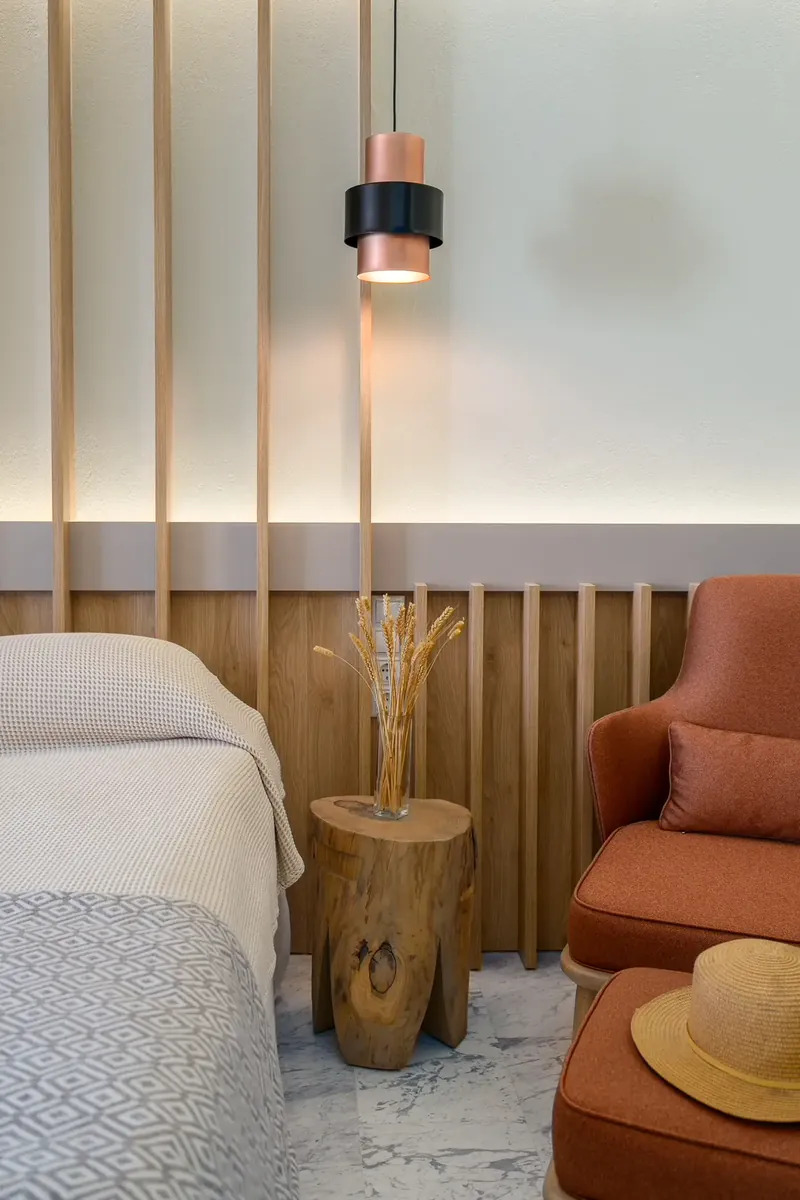 Un fauteuil et une suspension à côté du lit d’une chambre supérieure