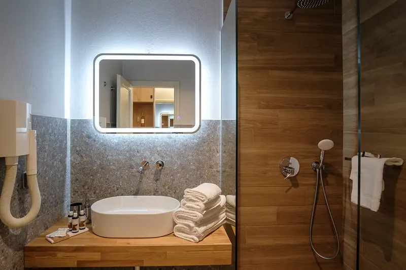 Le lavabo et le miroir éclairé de la salle de bains d’une chambre supérieure